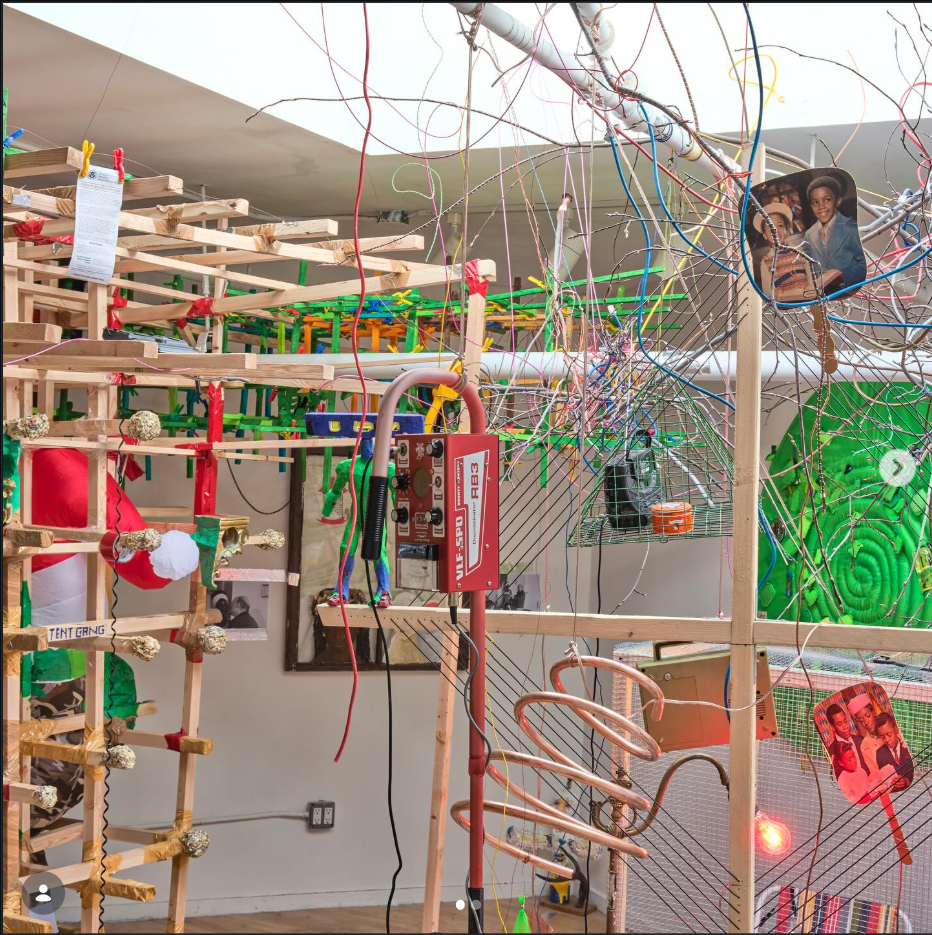 A large matrix of wood beams, within a smaller mesh of wires, within that even smaller elements